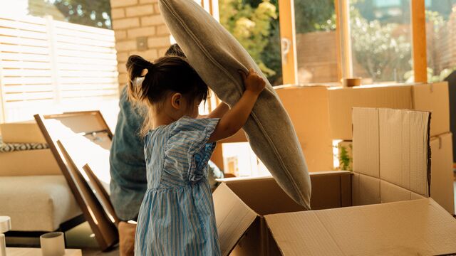 Child checking the contents of a moving box